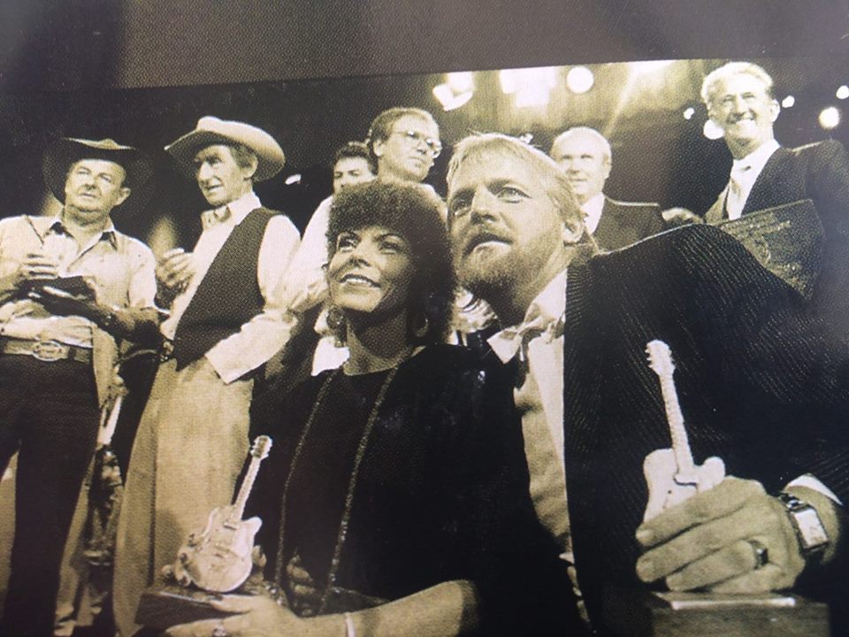 Evelyn Bury receiving her Golden Guitar in 1988 with Allan Caswell. In the background Slim Dusty and Smoky Dawson have also received Golden Guitars.