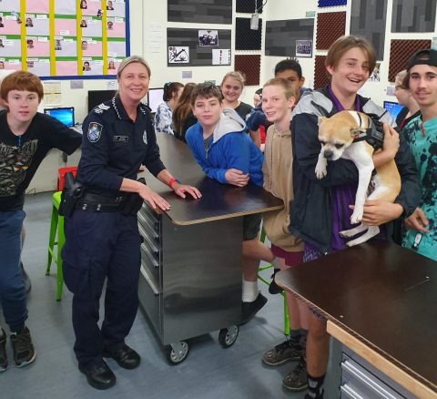 Sergeant Meg Owens and Tom Quinn Centre students with Rocky the classroom dog. 