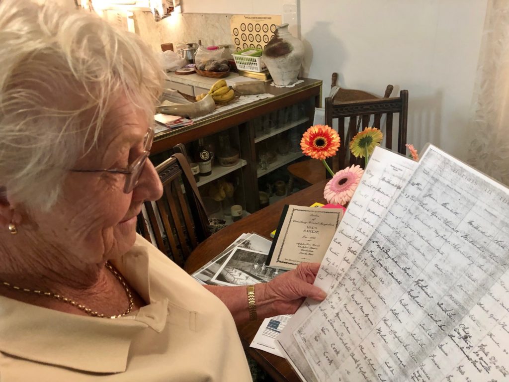 Doreen Cole perusing historical burial records at the South Isis cemetery.