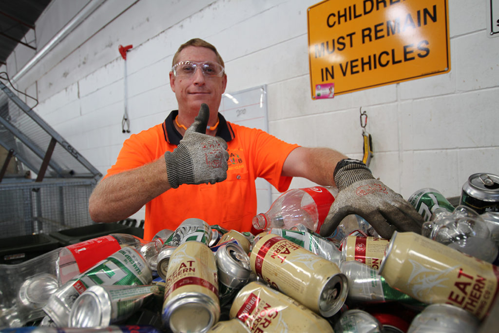 Chad Castles sorting through cans and bottles at ABC Recycling.