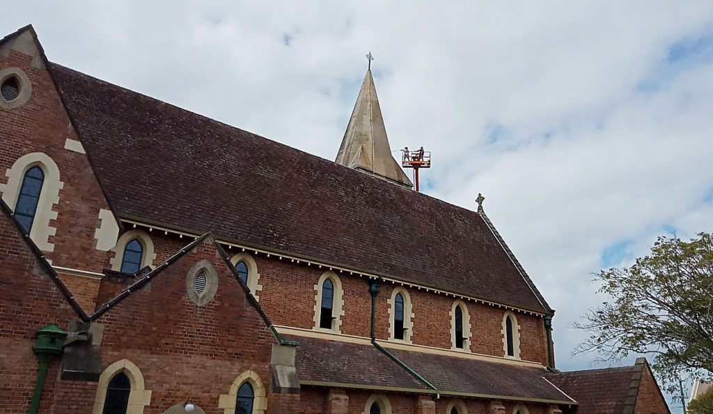 The painters working on the steeple. 