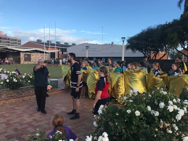 The Milbi Festival student performers rehearsing in Buss Park with Bundaberg Regional Council's Trevor Green and Robert McLellan.