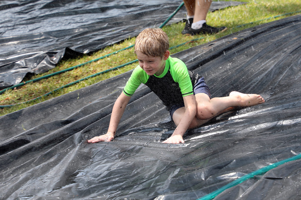 Dallas Walker hits the slippery slide at the water play event in Childers.