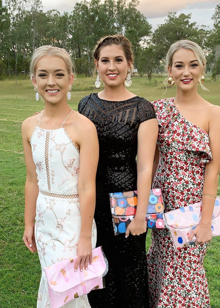 Chloe Johnson (far right) at the Gin Gin Show Ball last year with friends Emily Parsons and Makayla Chapman. All three are carrying clutches designed and made by Chloe.