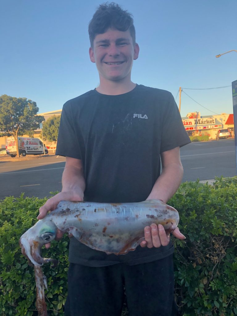 Cody Lentas with the squid he caught using a metal slug