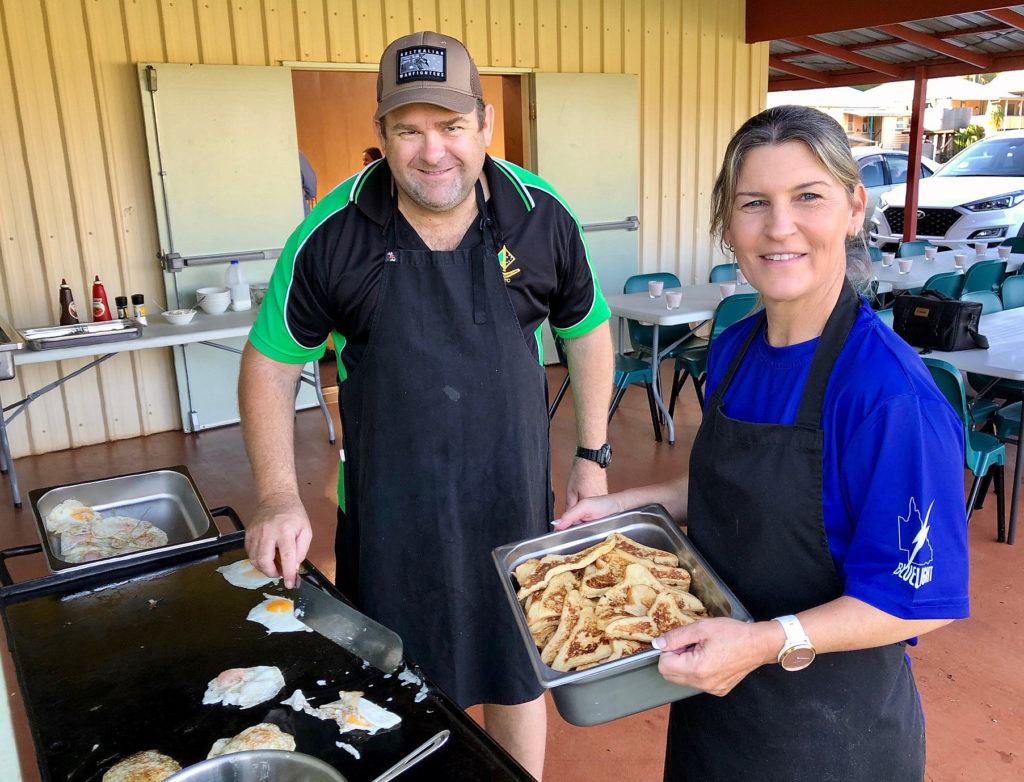 High School staff member Renee Adams and volunteer cook Brett Dittman prepare breakfast for the Blue Edge participants.