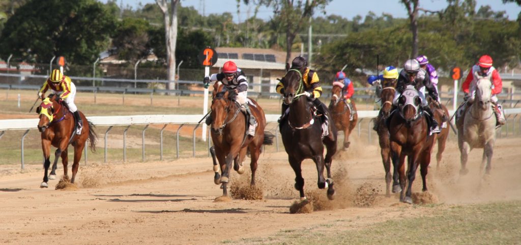 Wrecking Ball (centre in gold and black colours), ridden by Hannah Richardson races to the front on the way to winning the Benchmark 55 Handicap.