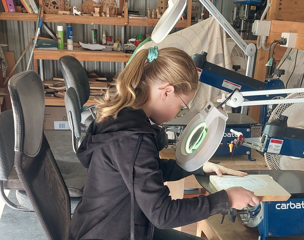 Bundaberg Woodworkers youngest member, Charlie-Rose Urry working on her project. woodworkers showcase