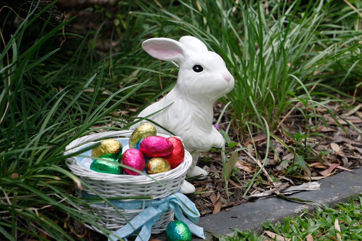 Rabbit statue and Easter eggs sitting in a garden