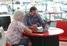 Library staff assist community members with technology support sessions.