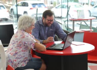 Library staff assist community members with technology support sessions.