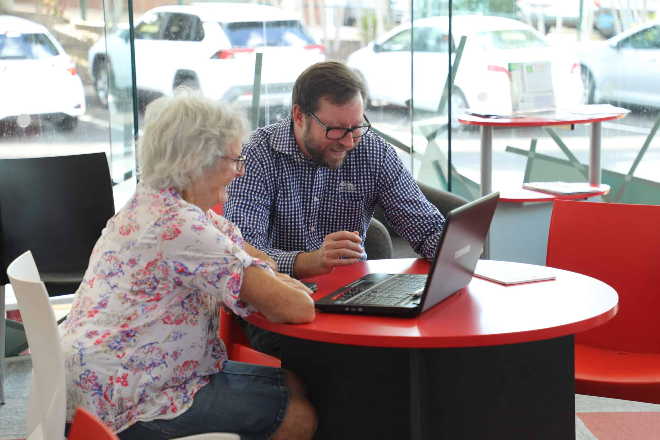 Library staff assist community members with technology support sessions.